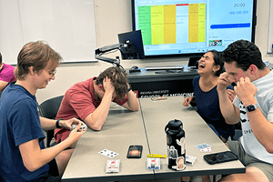 Four students from IU School of Medicine enjoy playing cards at around a table.