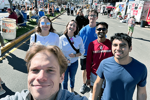 Six students from IU School of Medicine's Evansville campus pose for a selfie in the street at the 2024 West Side Nut Club Fall Festival.