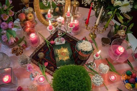 flowers food and candles on a table prepared for naw ruz or persian new year