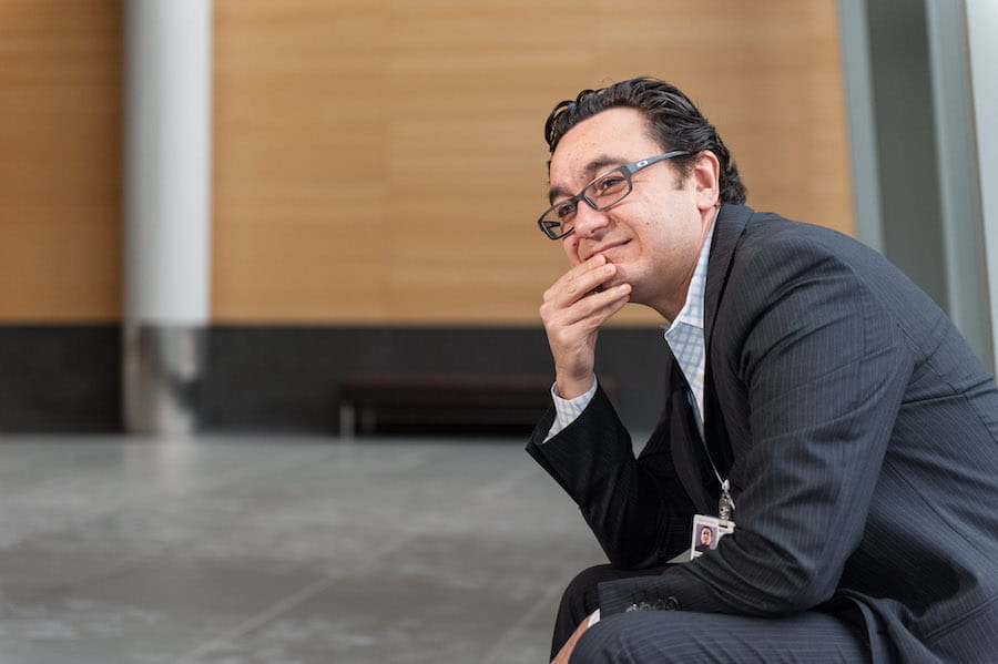 A man in a suit sits in a hallway
