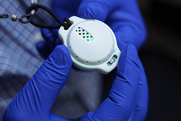 person with gloves on holding breathalyzer device  