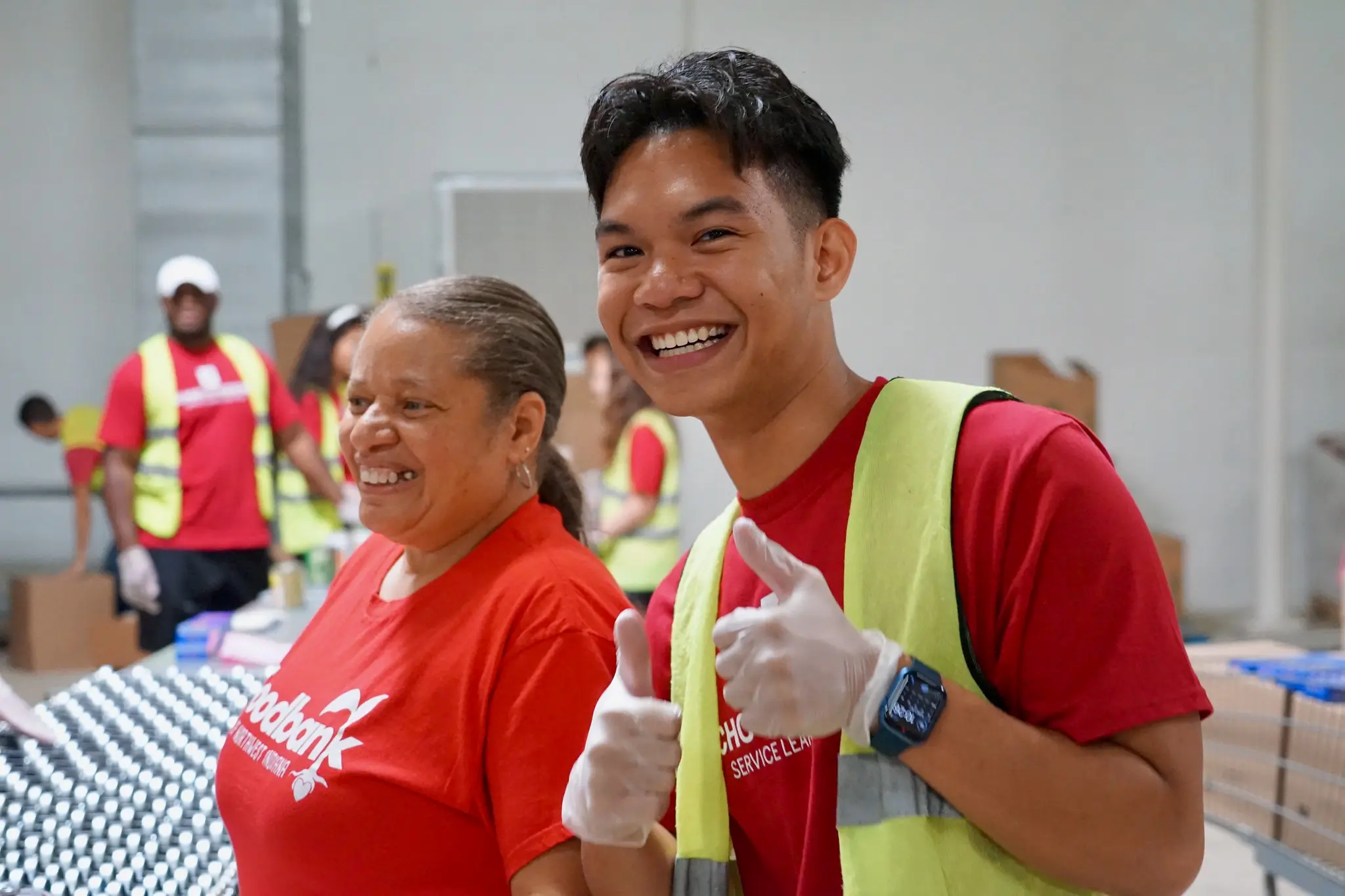 a student gives two thumbs up while working at the food bank in Gary.