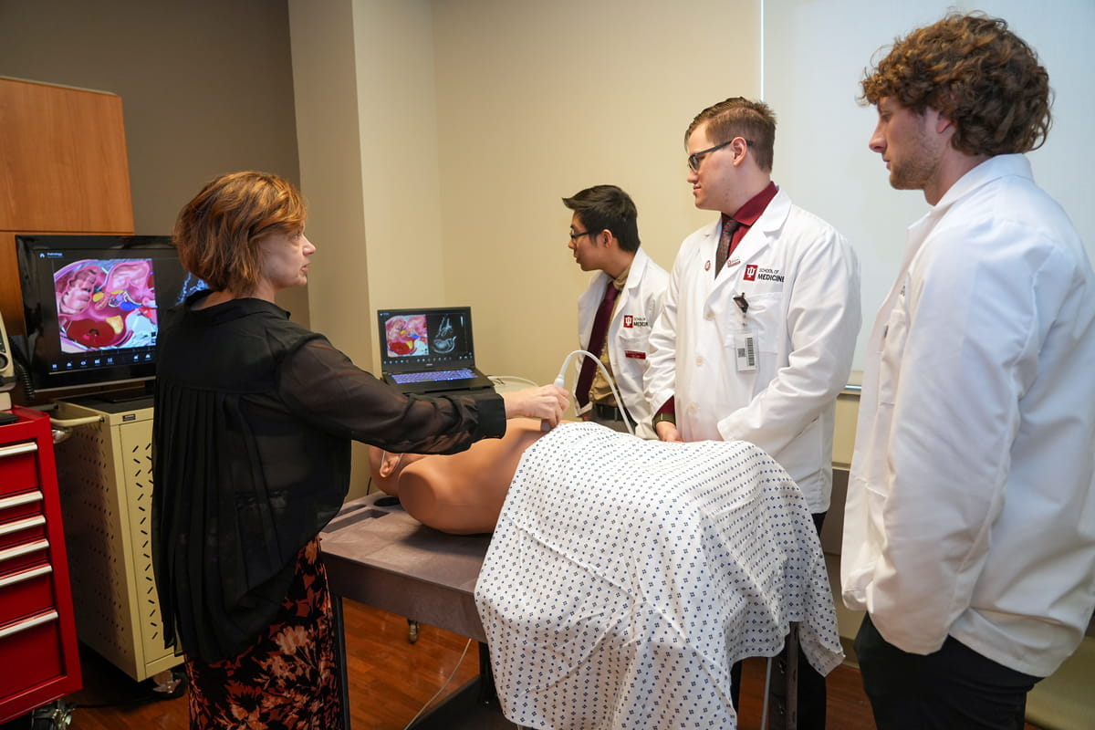 faculty member and student speak together at a table