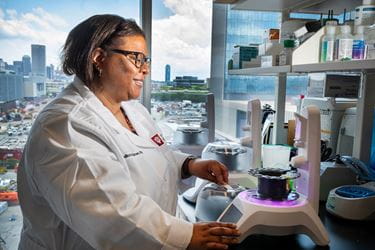Candice Brown works in her research lab with the Indianapolis skyline in the background