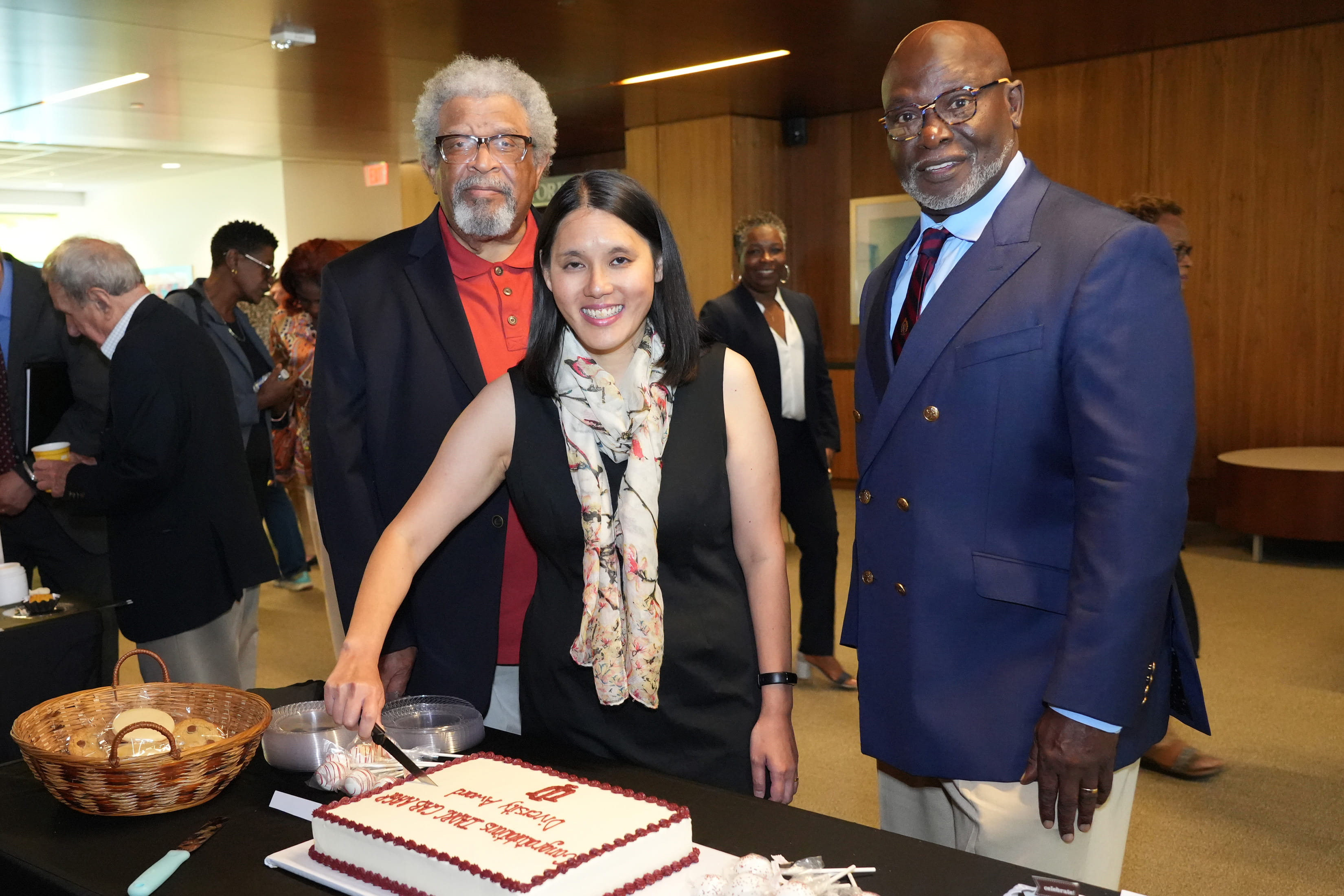 Three CAB members cutting a cake during a 2023 celebrating