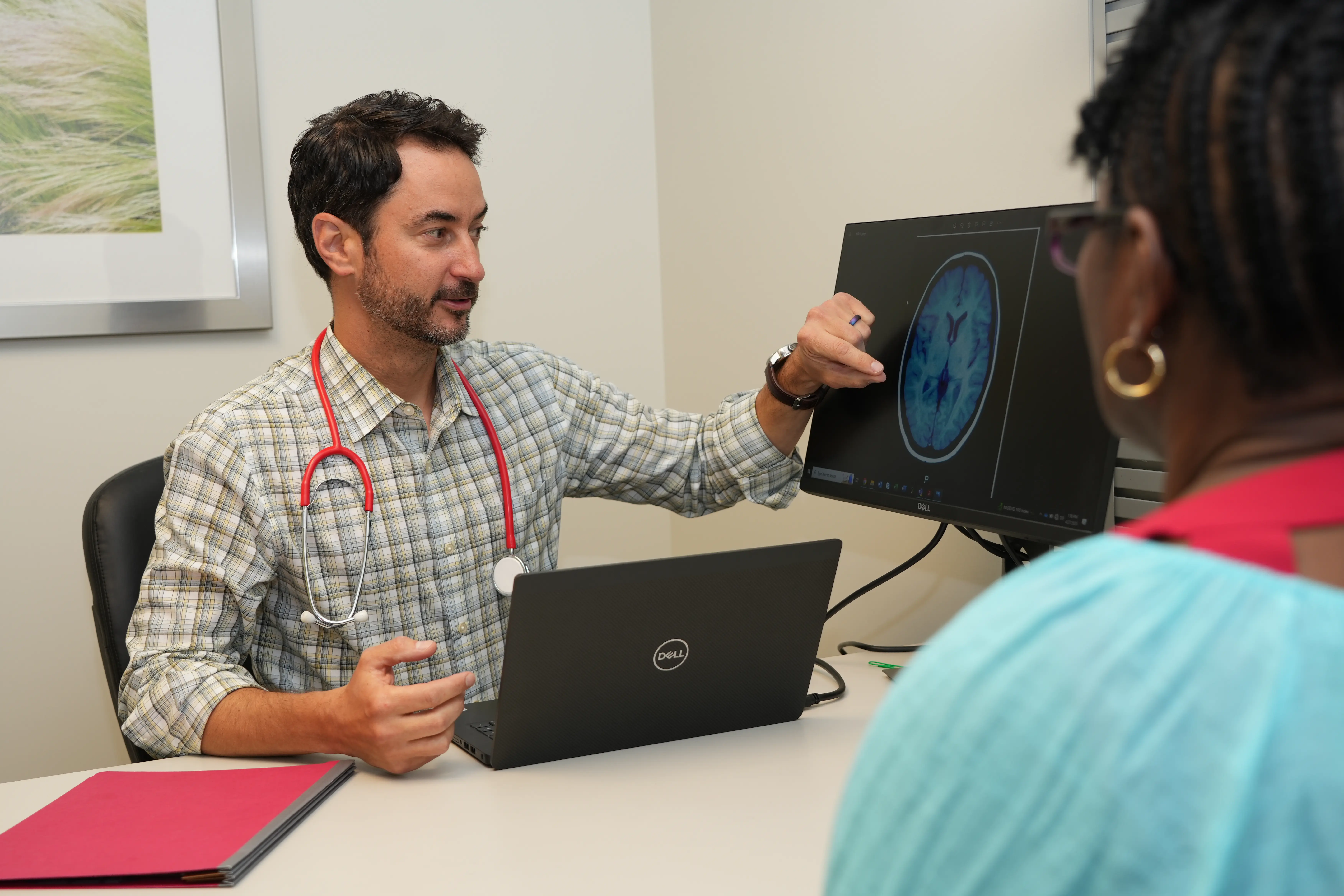 a physician talks through imaging results with a clinical trials participant