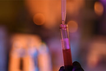 Test tube being pipetted with out of focus background.