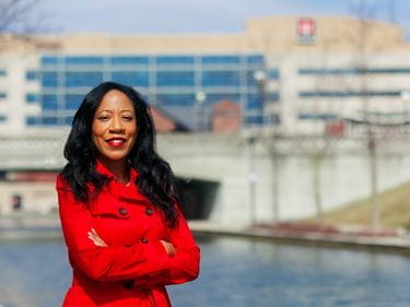 Khadijah Breathett, MD is photographed along the canal, with IU Health building in the background.