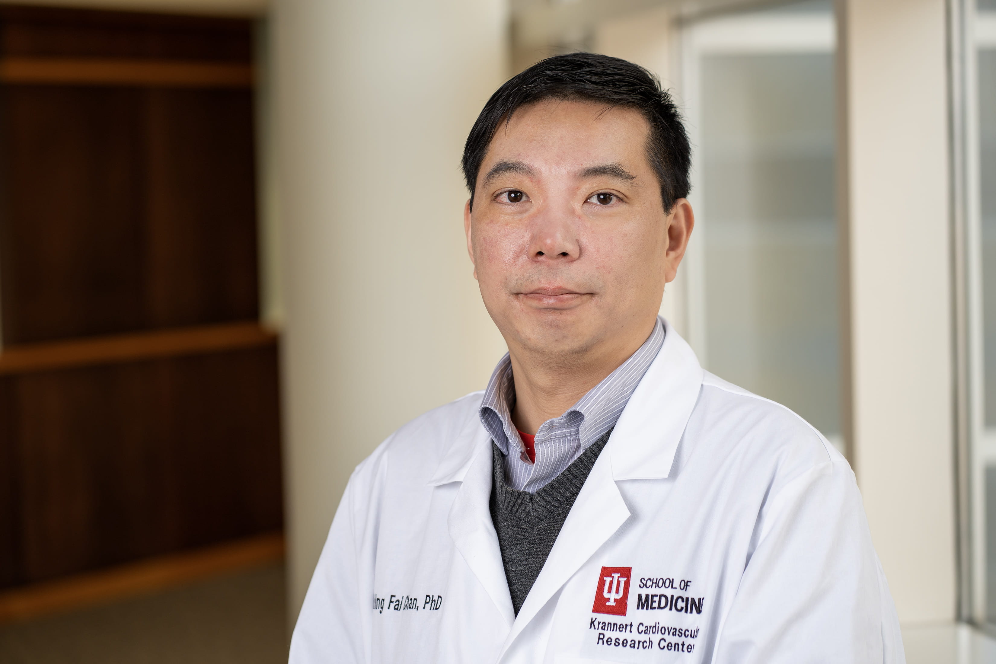 Shing Fai Chan, PhD, in white lab coat.