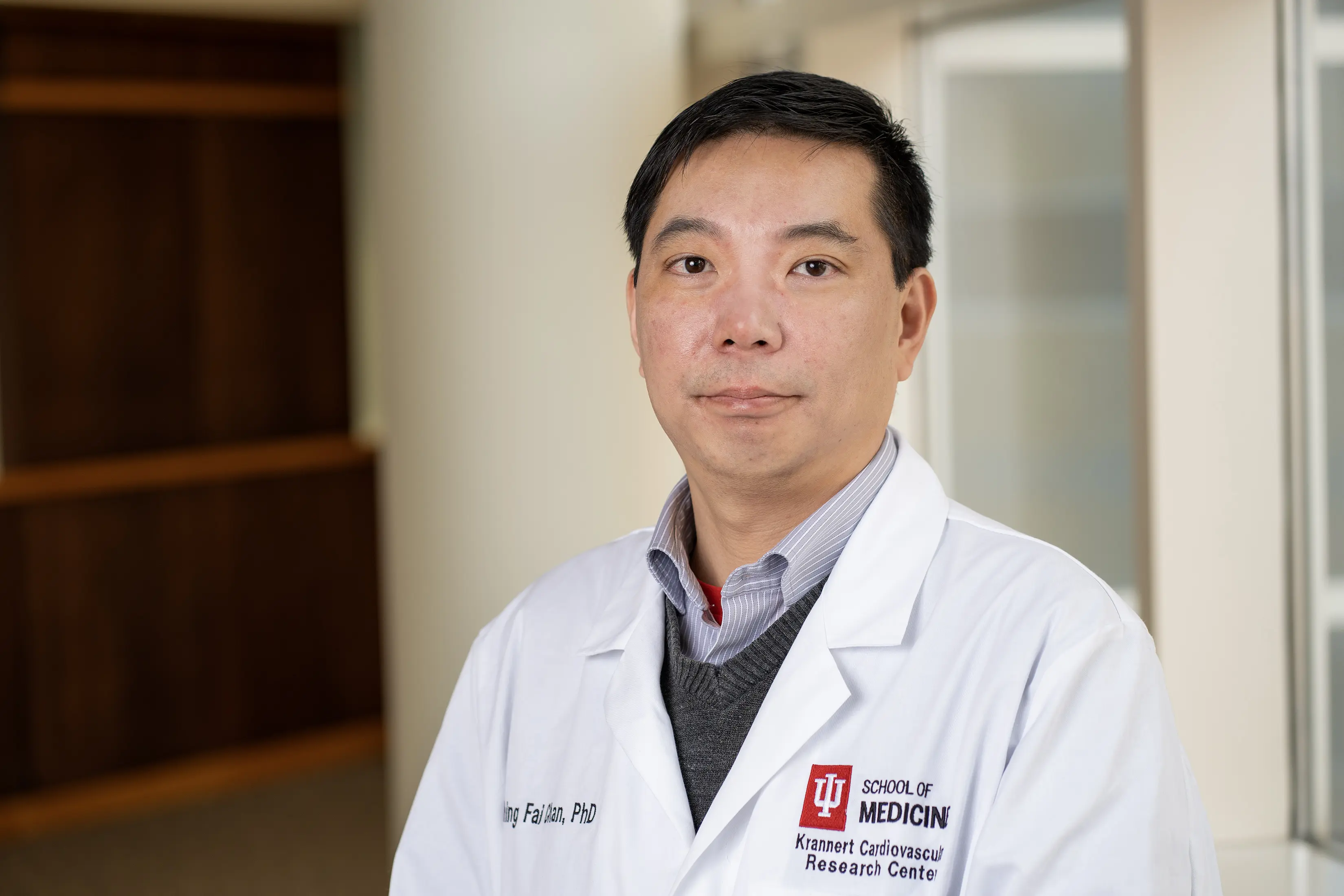 Shing Fai Chan, PhD, in white lab coat.