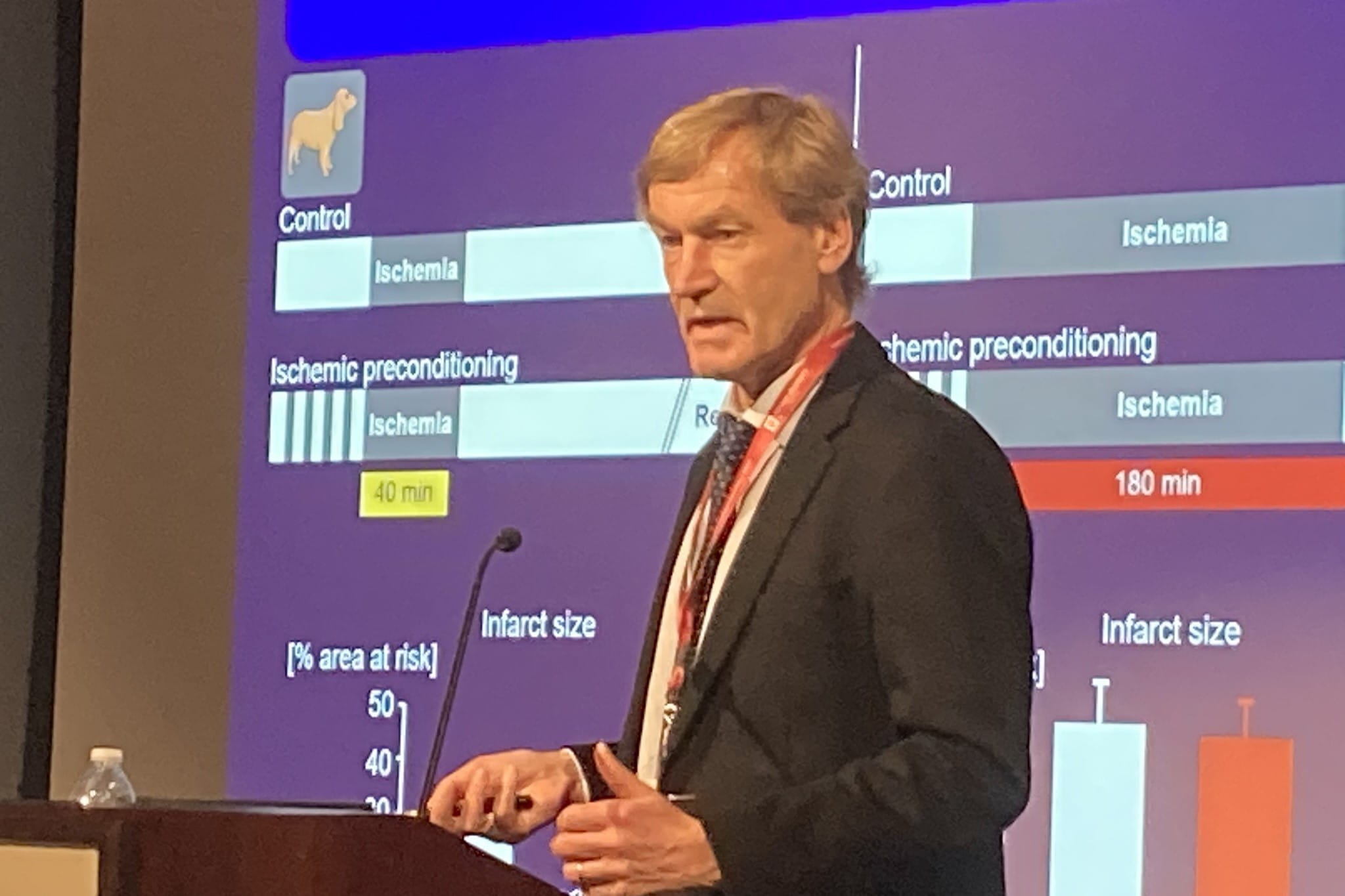 gerd heusch presents at a podium