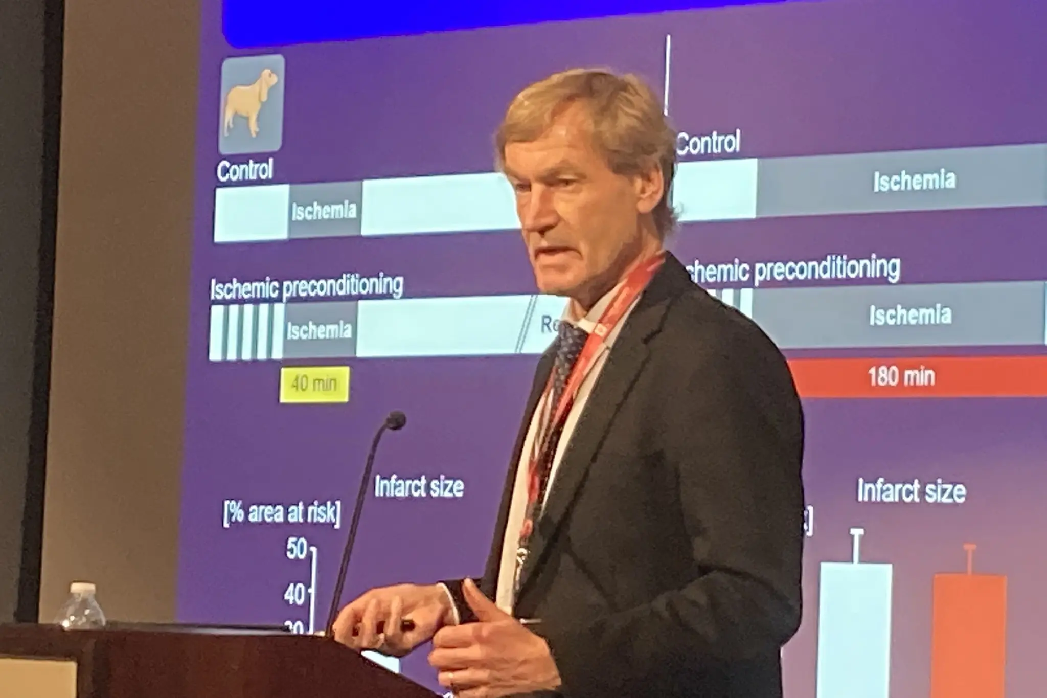 gerd heusch presents at a podium