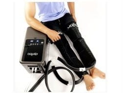Illustration shows figure using heat therapy system comprised of water circulating trousers and water pump.