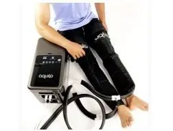 Illustration shows figure using heat therapy system comprised of water circulating trousers and water pump.