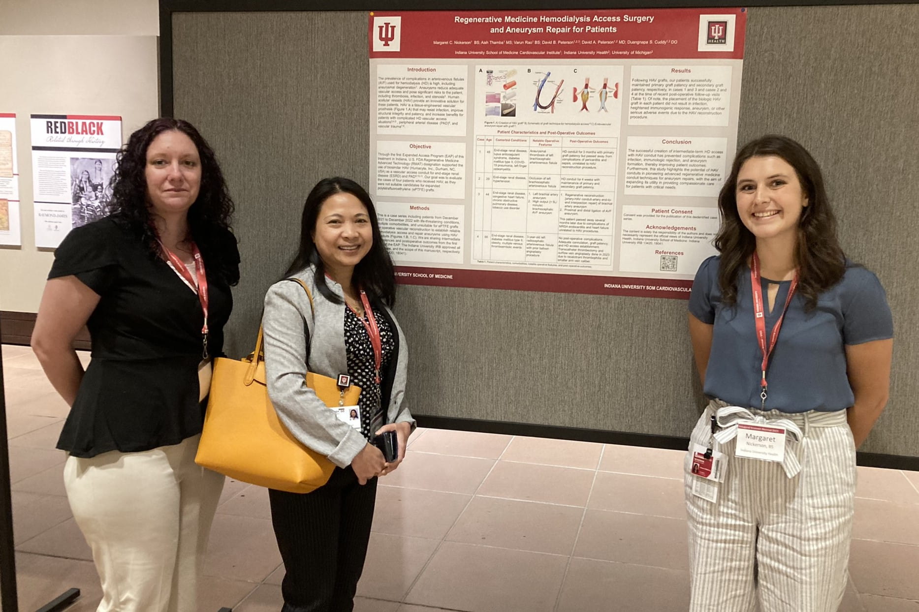 researchers stand in front of their poster presentation