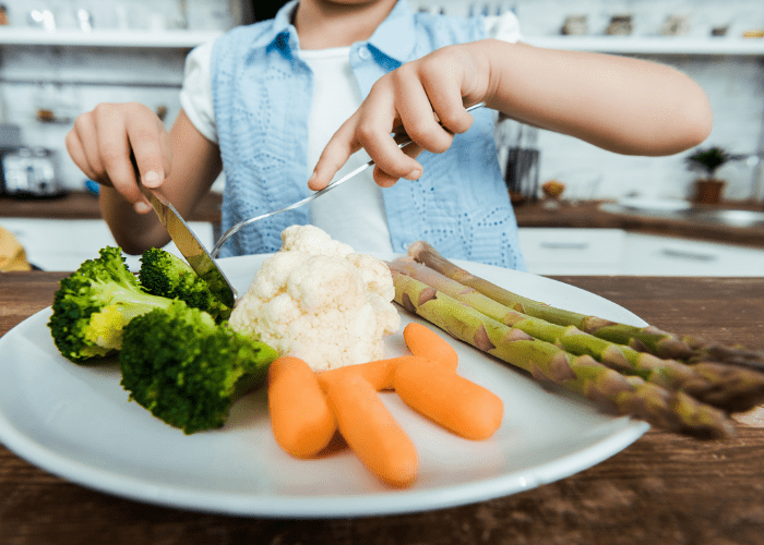 child cutting vegetables