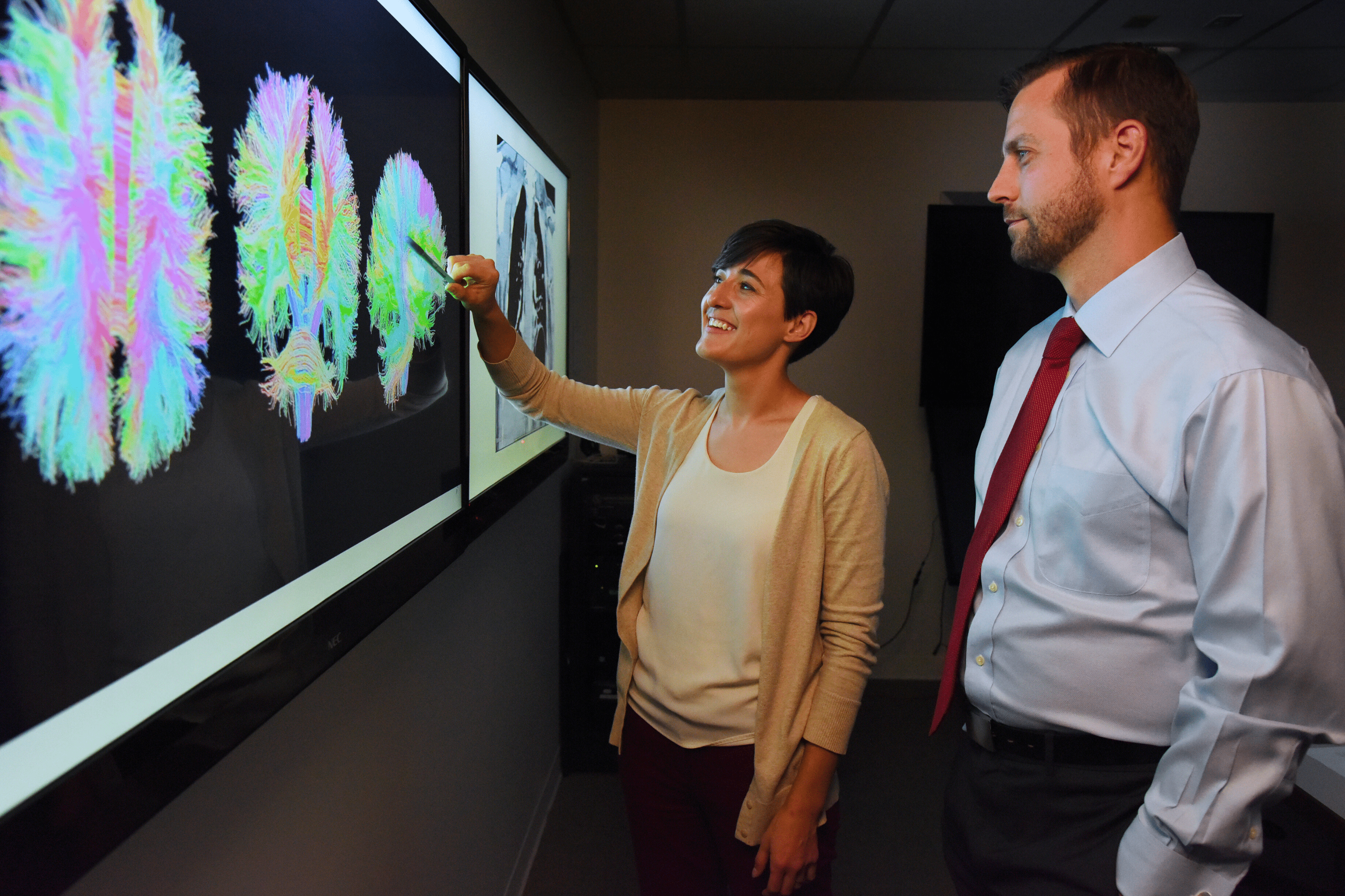 Two researchers, one male and one female, view neuro images.