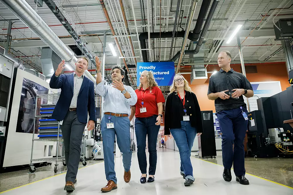 Rickie Witte, Amrou Awaysheh, Jill Fehrenbacher, Melissa Kacena and Orsa Britton stride down the hallway of an orthopedic research and manufacturing facility