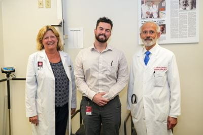 three members of the administrative team in white lab coats