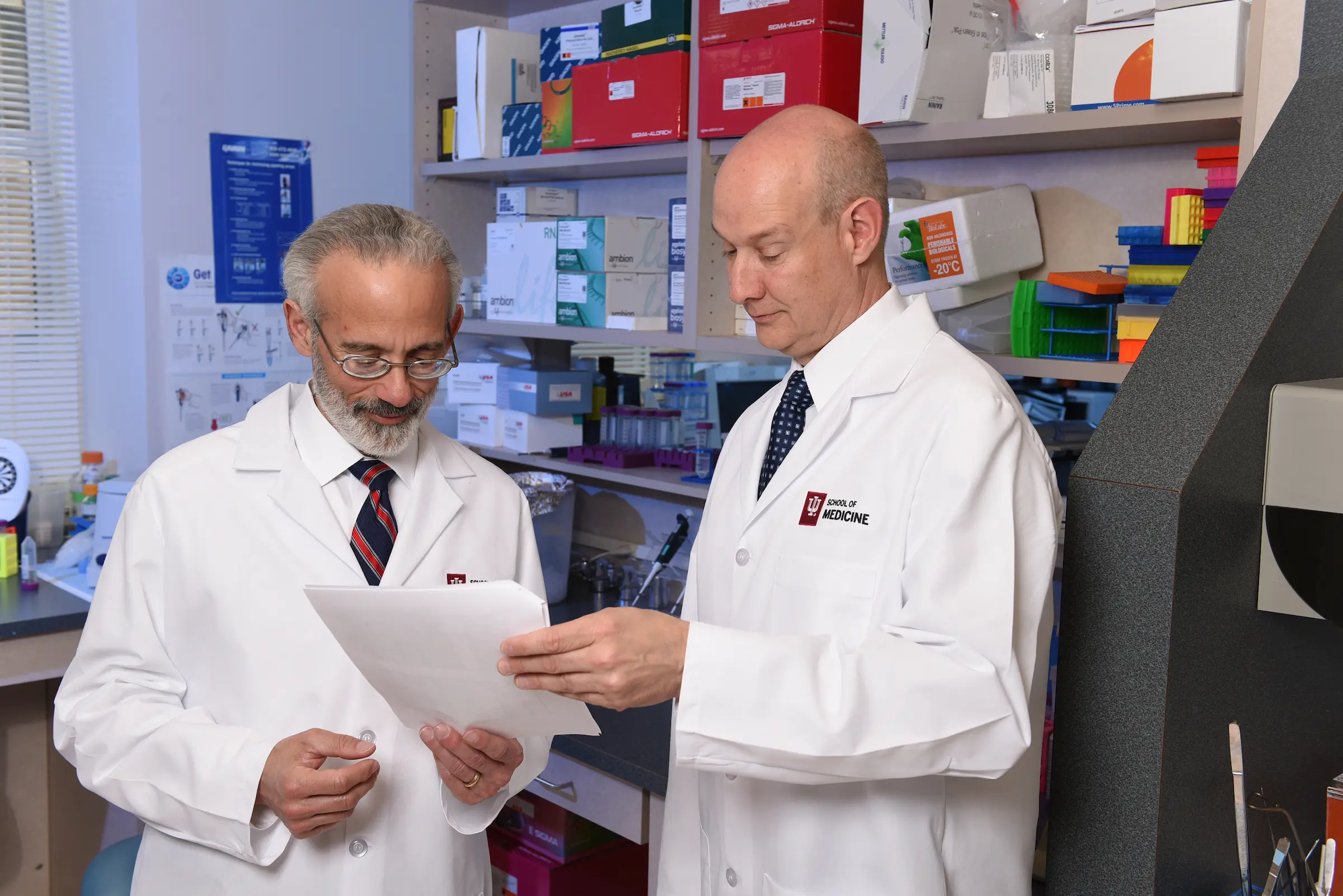 Drs. Econs and White discuss research results in the lab