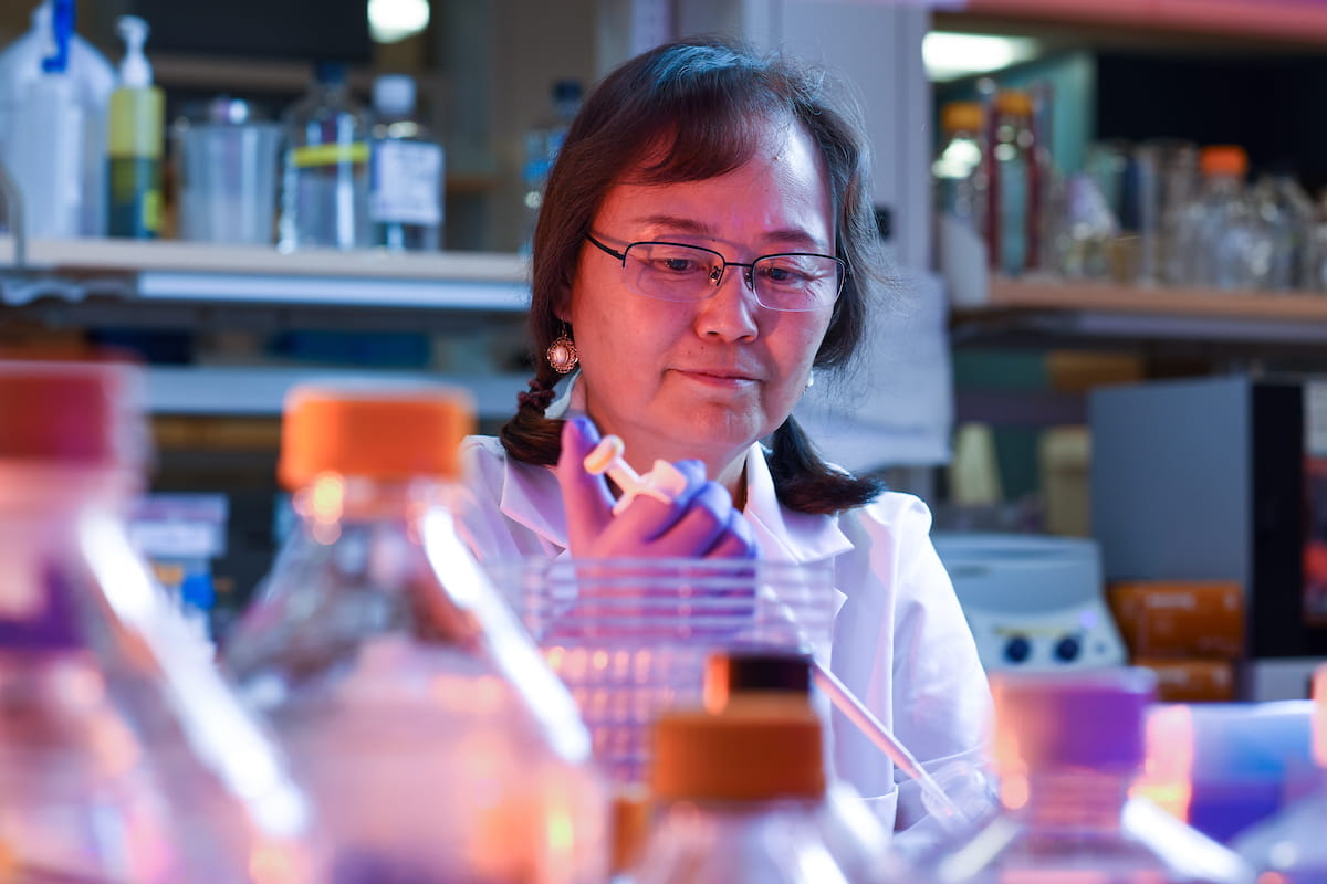 a researcher in a white coat prepares samples in the lab