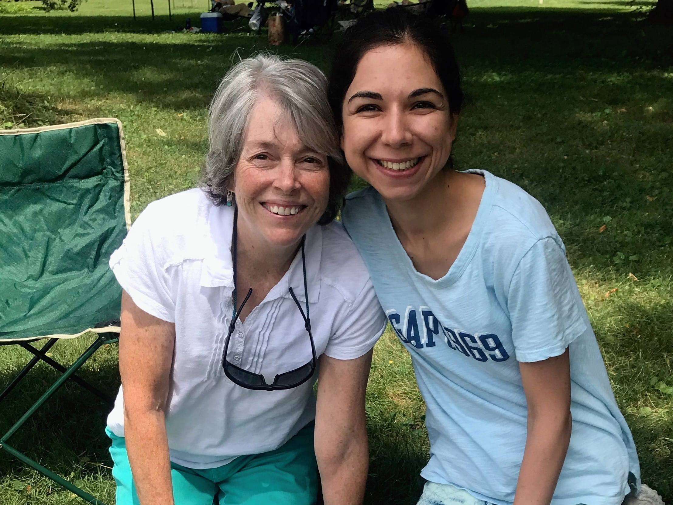two people pose for a picture at a park