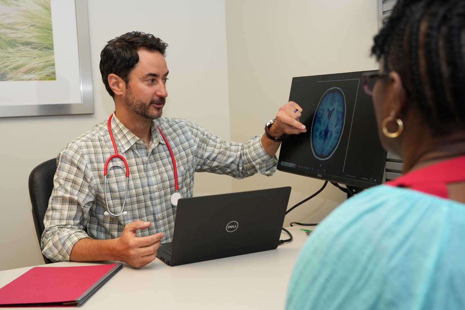 Jared Brosch reviews a brain scan with a patient