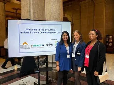 Three people pose for photo at research event