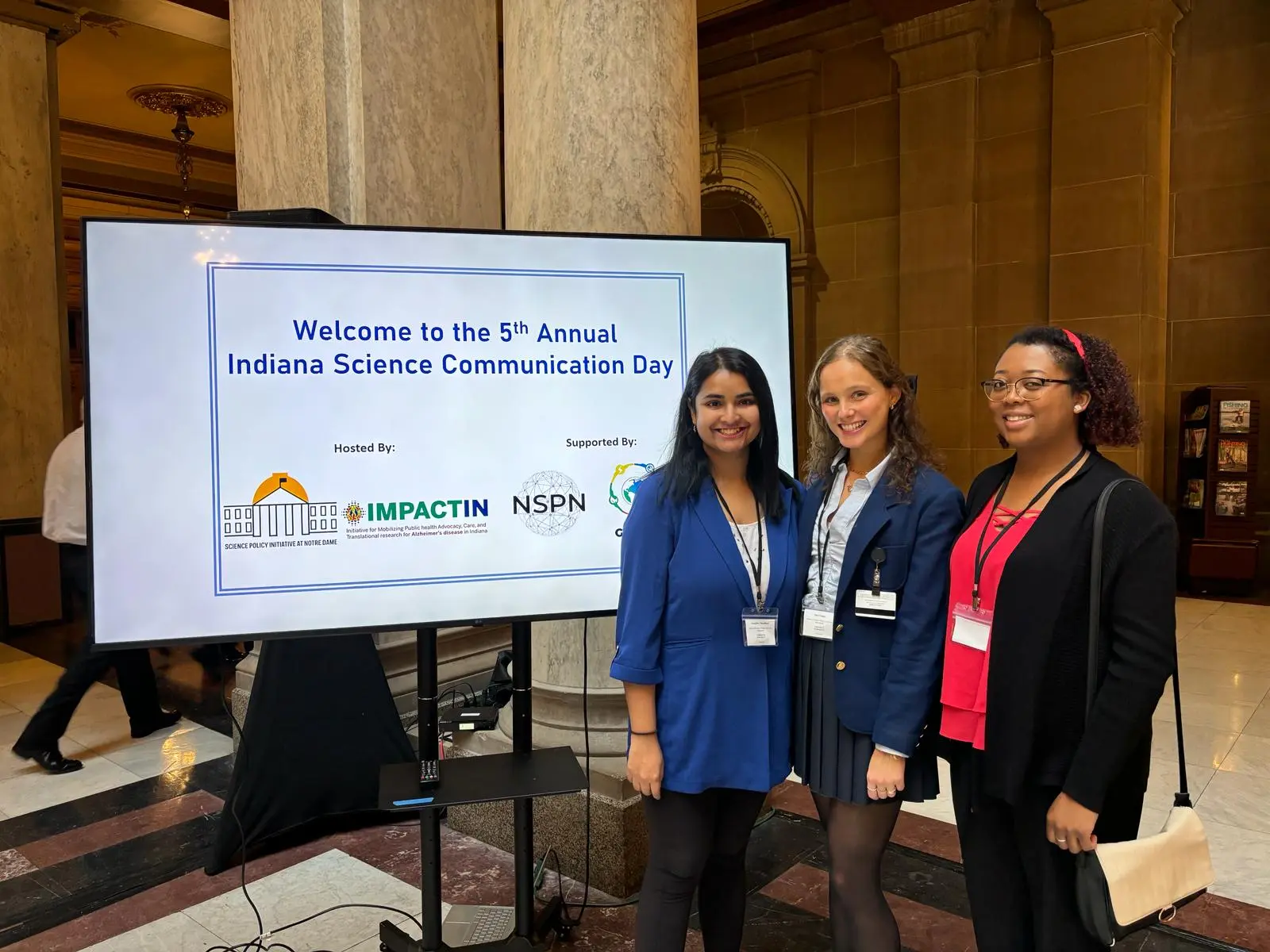 Three people pose for photo at research event