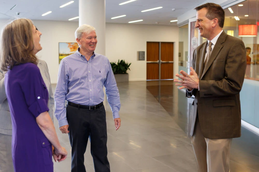 three people chat in a lobby