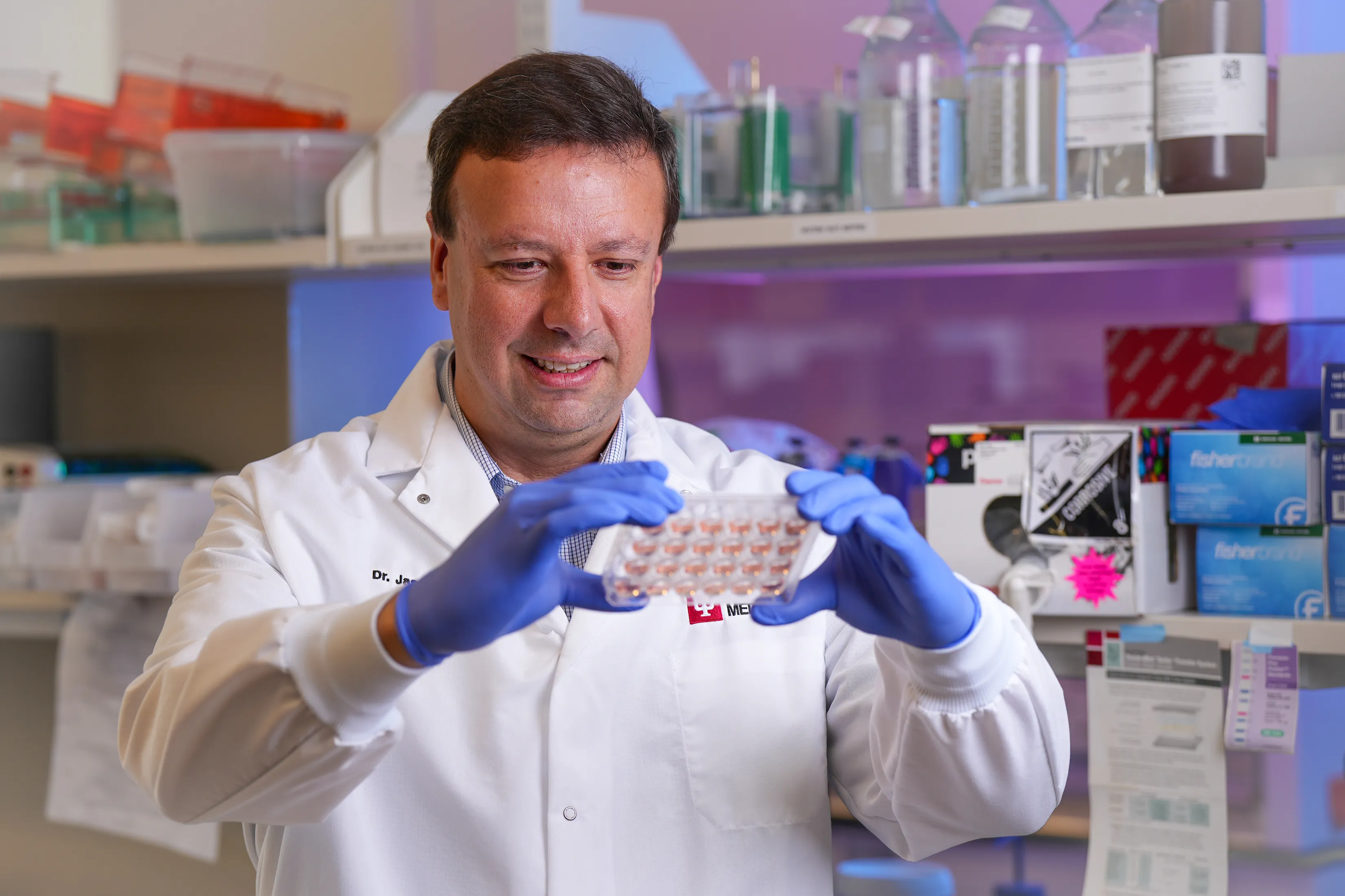 a researcher holds a microplate