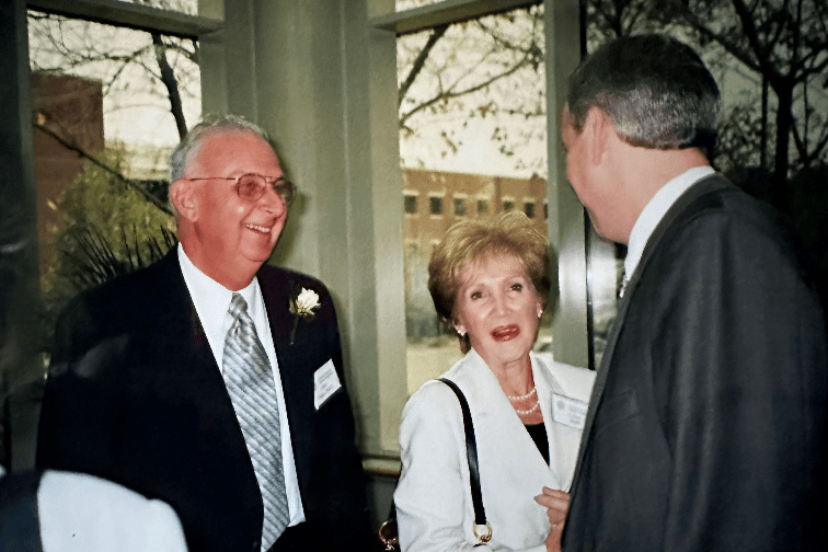 three people speak at a ceremony