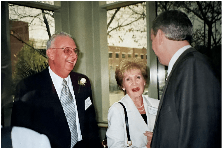 three people speak at a ceremony