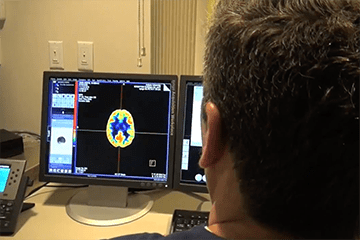 a person looking at a brain scan on a computer screen
