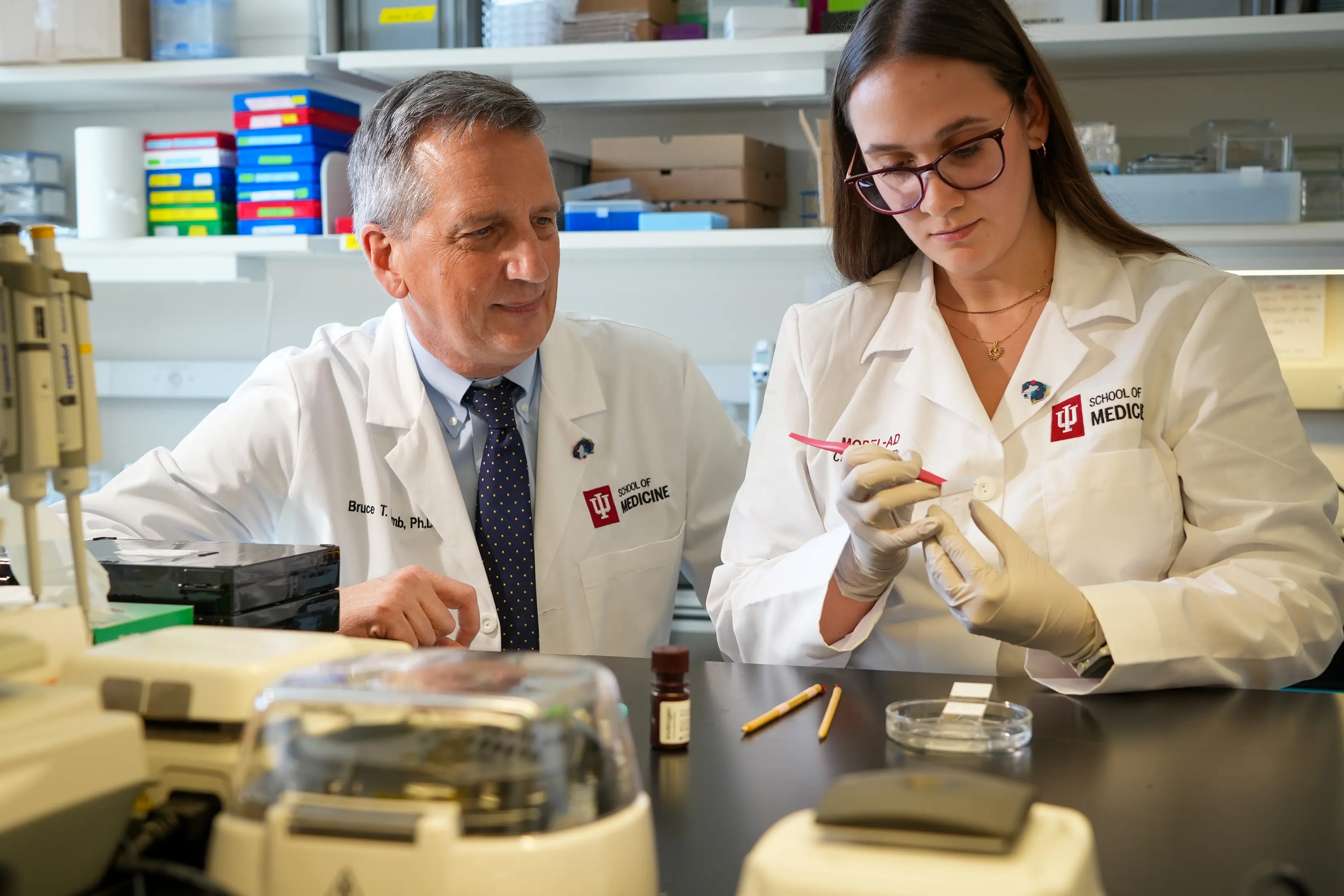 an investigator and lab worker sit at a table