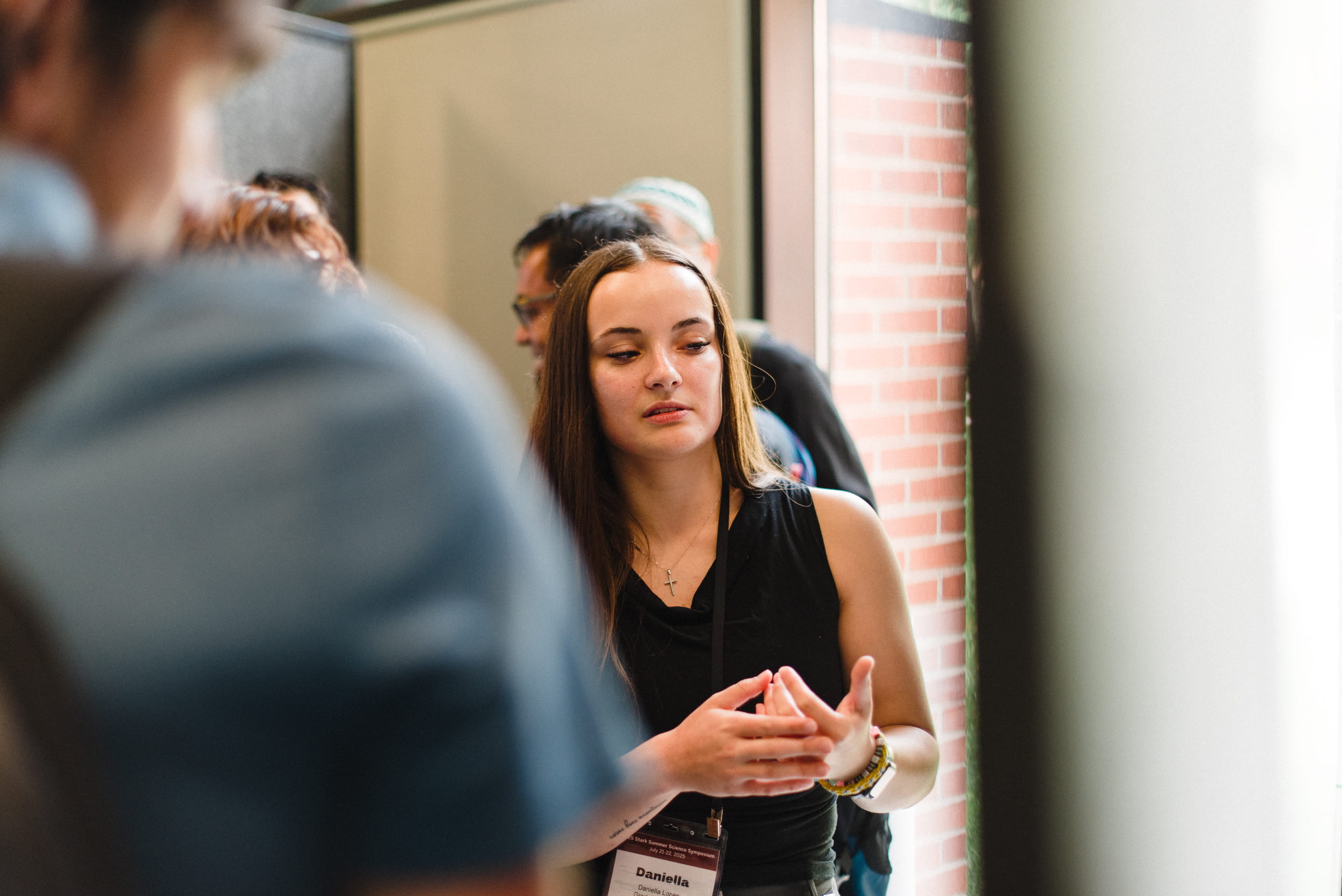 Daniella Lopes presents her research to other people at a symposium