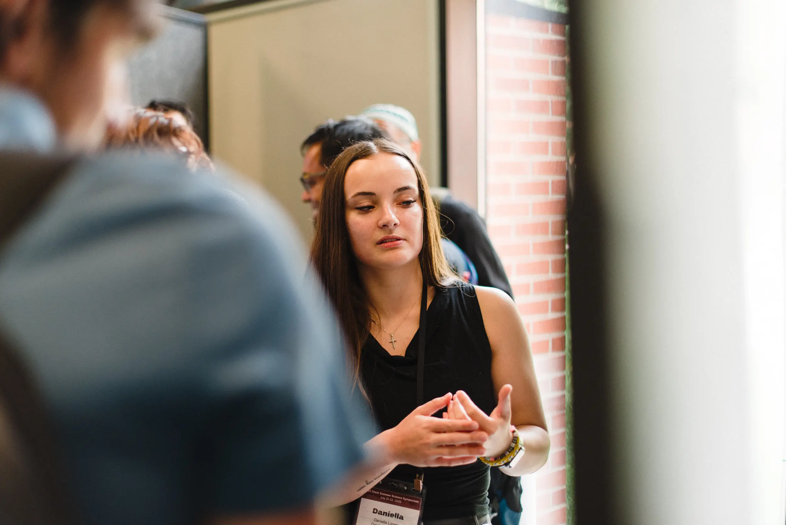Daniella Lopes presents her research to other people at a symposium