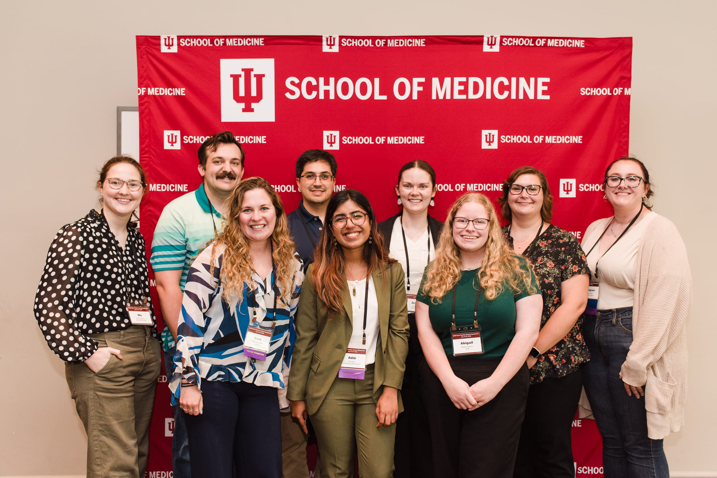 a group photo in front of a branded background