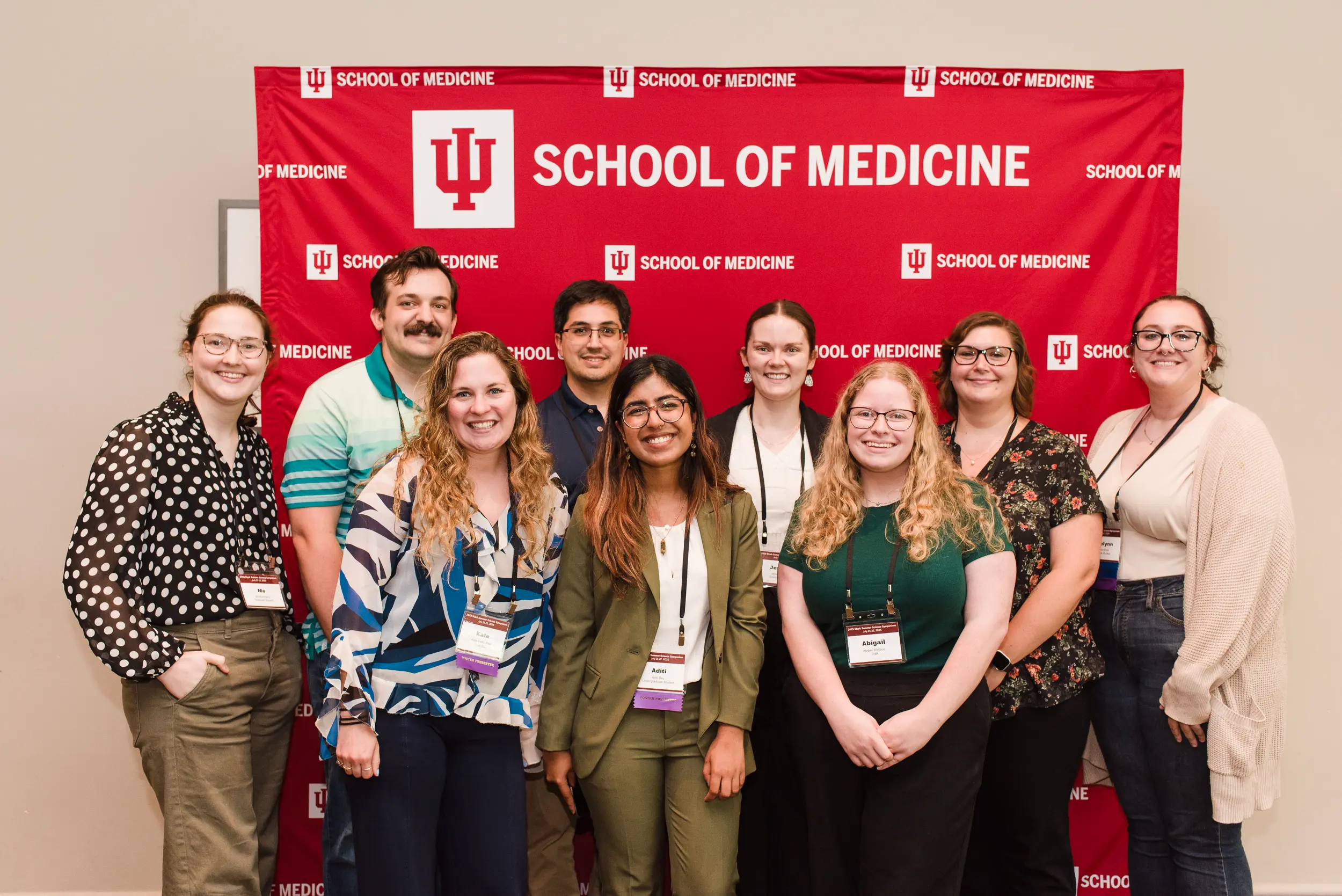 a group photo in front of a branded background