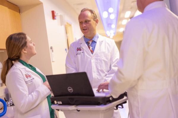 Andrew Schwaderer speaking with colleagues Michelle Star and David Haines at Riley Hospital for Children