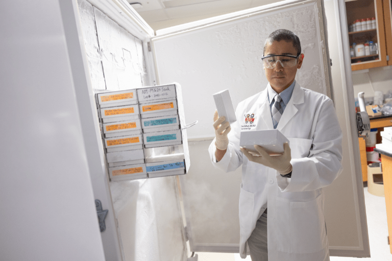 Brian DeBosch, MD, PhD pulling out materials from the freezer in a research lab