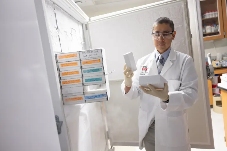Brian DeBosch, MD, PhD pulling out materials from the freezer in a research lab