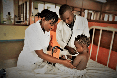 Clinicians at Mulago Hospital in Kampala, Uganda check on a patient