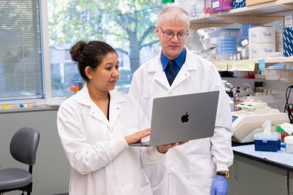 Naro Biswas and Roland Herzog looking at a laptop in a lab