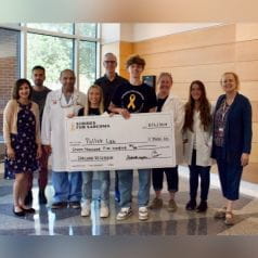 Strides for Sarcoma representatives and Wells Center researchers post with large donation check
