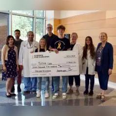 Strides for Sarcoma representatives and Wells Center researchers post with large donation check