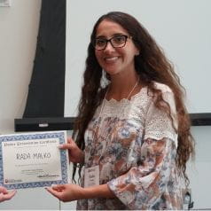 Rada Malko posing with her 2024 Wells Center Retreat poster award certificate