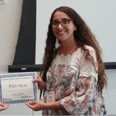 Rada Malko posing with her 2024 Wells Center Retreat poster award certificate 