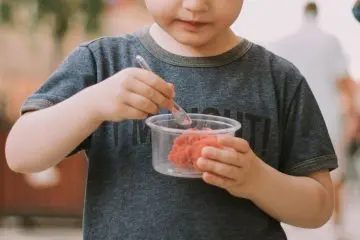 Child eating ice cream in a cup