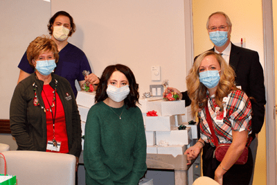 Five members from the Wells Center for Pediatric Research pose in front of a cart full of donut boxes